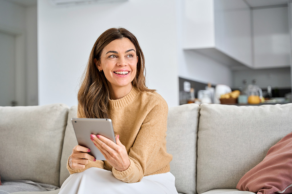 Woman on a couch using her tablet computer